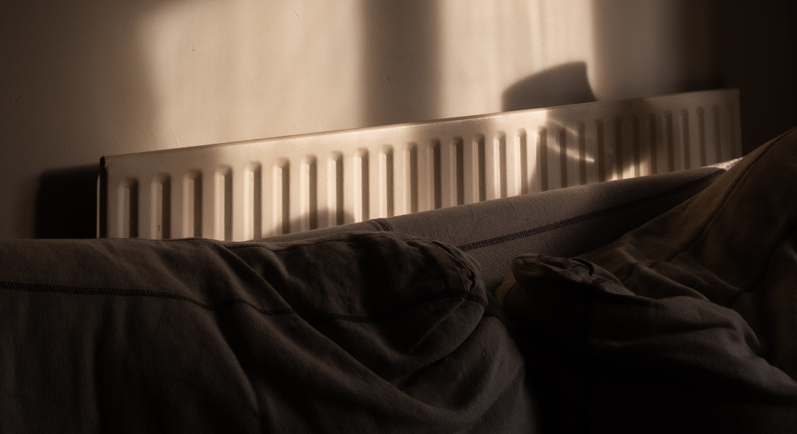 a radiator behind a large sofa